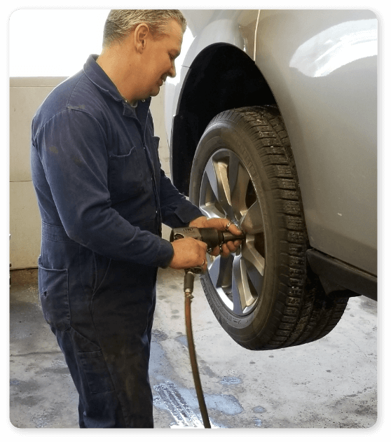 An Dave Murdock of Hemlock Auto & Alignment secures a tire onto a car | Alignments