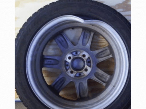 Car shaking due to bent rim in Hemlock, MI. Closeup image of tire with bent rim at Hemlock Auto & Alignment.